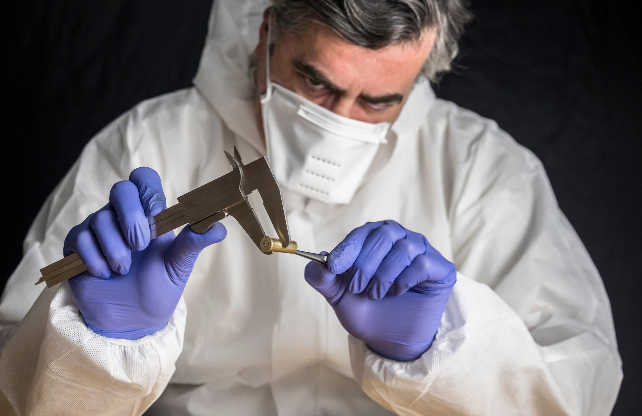 Expert Police measures bullet caliber in ballistic lab, conceptual image